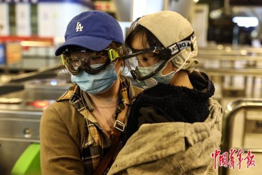 3月28日，武汉火车站，一名小女孩和妈妈准备乘坐地铁。? 中国青年报 图